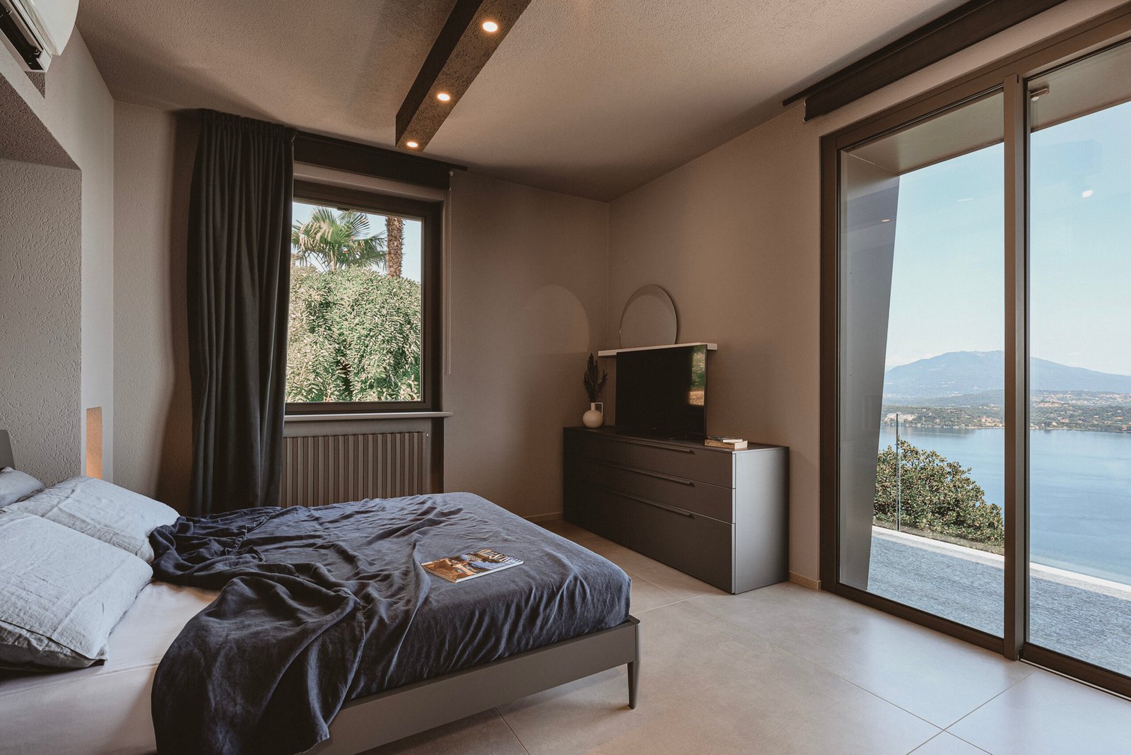 Picture of Villa Falcone's master bedroom with TV and lake view.